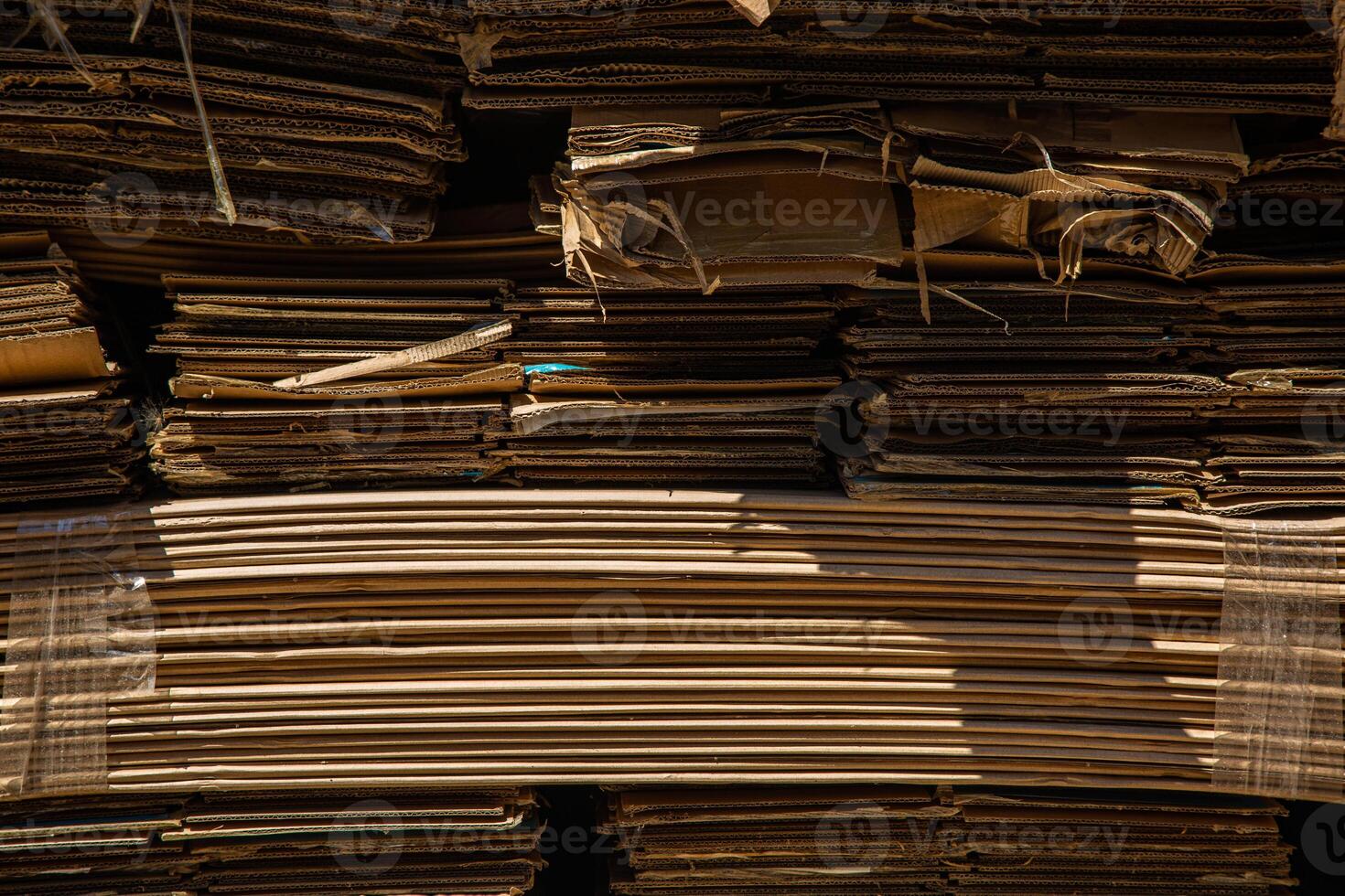 Stack of corrugated paper waste before sending to shred and recycle at recycling plant. Corrugated fiberboard. Old, randomly folded paper. photo