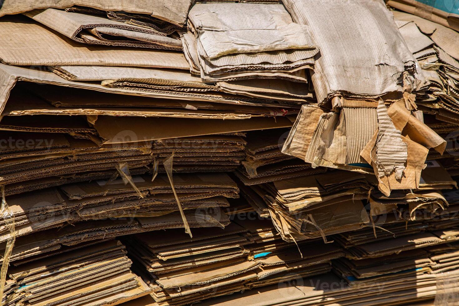 Stack of corrugated paper waste before sending to shred and recycle at recycling plant. Corrugated fiberboard. Old, randomly folded paper. photo
