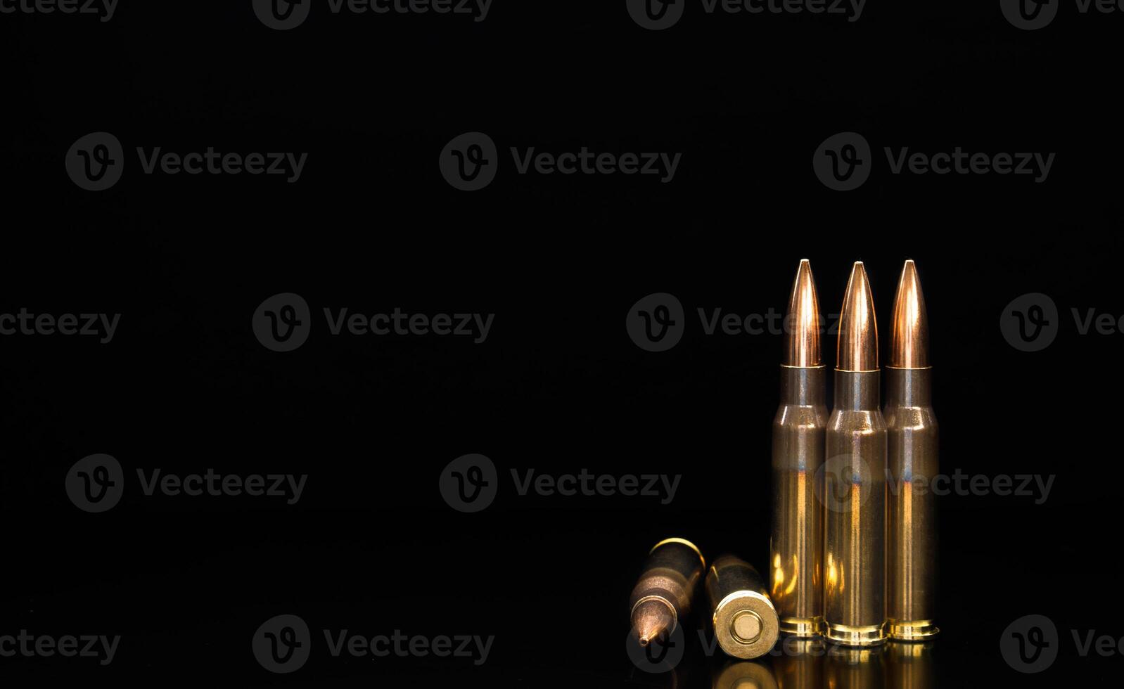 Rifle bullets close-up on black back. Cartridges for rifle and carbine on a black. Bullet isolated on black background with reflexion. photo