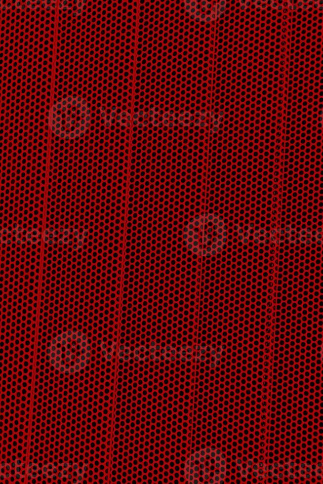 Red background of wavy metallic grid with holes. Metal mesh as back. Perforated metal. photo