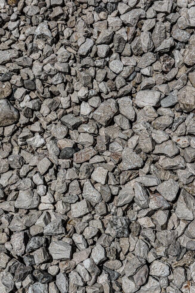 The texture of fine gravel. Granite gray back. Lots of small stones lying on the ground. photo