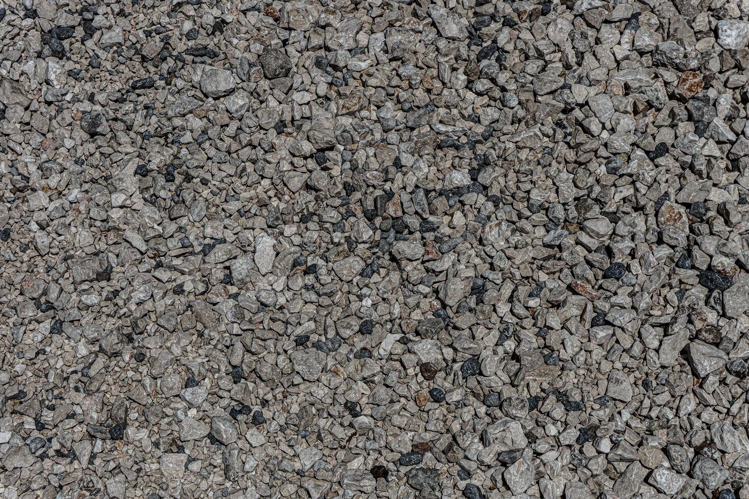 The texture of fine gravel. Granite gray back. Lots of small stones lying on the ground. photo
