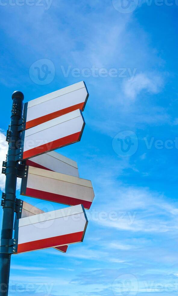 Blank directional road signs against blue sky. Directional sign post. Blue back. photo