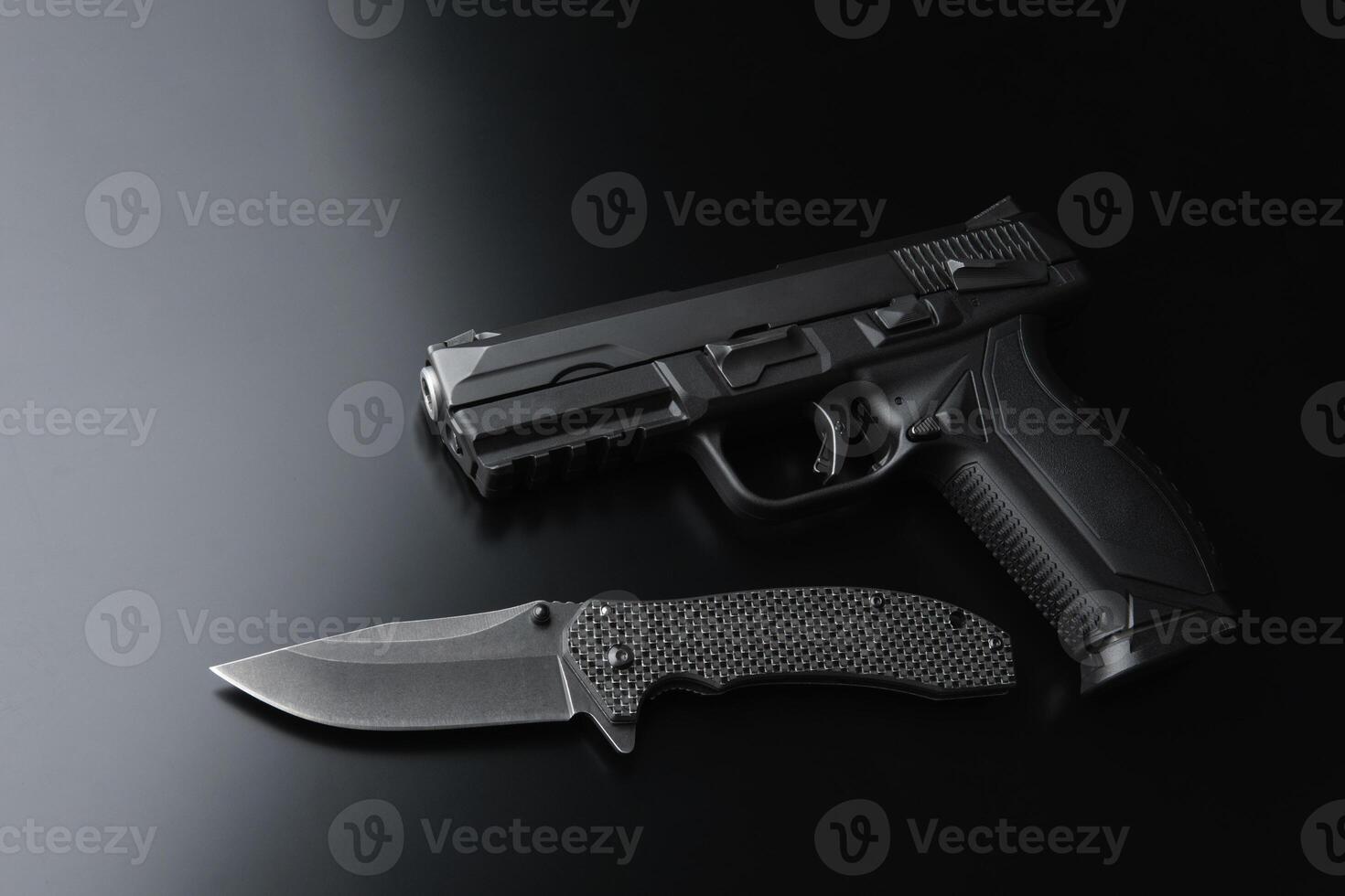 Black modern pistol on a dark back. A short-barreled weapon for concealed carry. Armament of the police, army and special units. photo