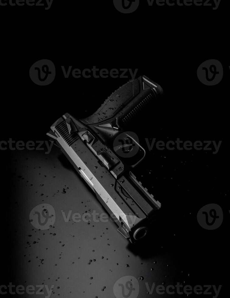 Modern black pistol on a dark back. Armament for the police, army and special forces. A short-barreled weapon for defense and attack. photo