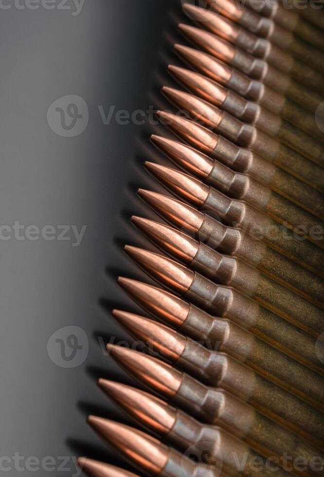 Rifle bullets close-up on black back. Cartridges for rifle and carbine on a black. Bullet isolated on black background with reflexion. photo