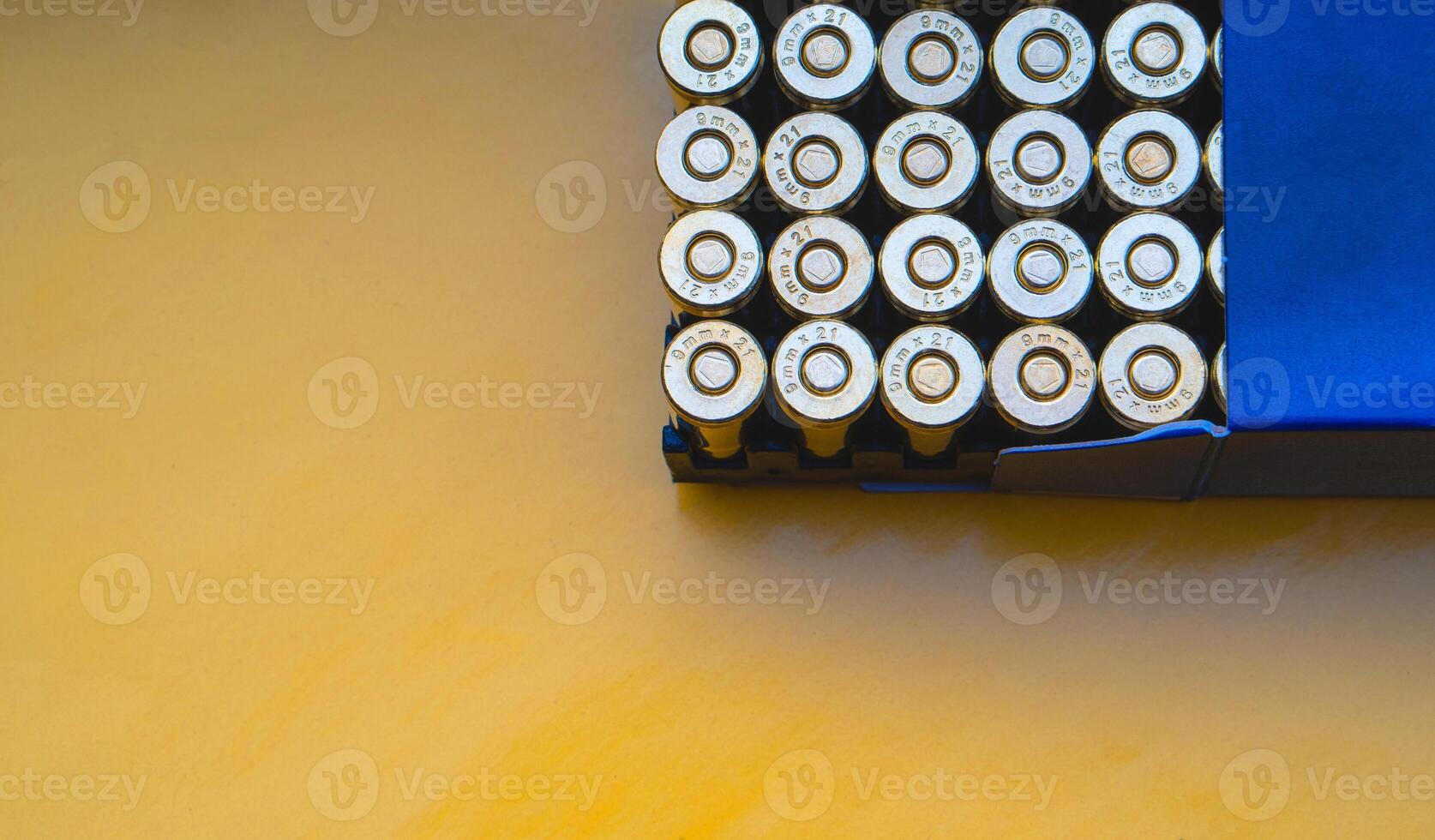 Cartridges in a blue box on a background of a yellow target. 9 mm cartridges for firearms. photo