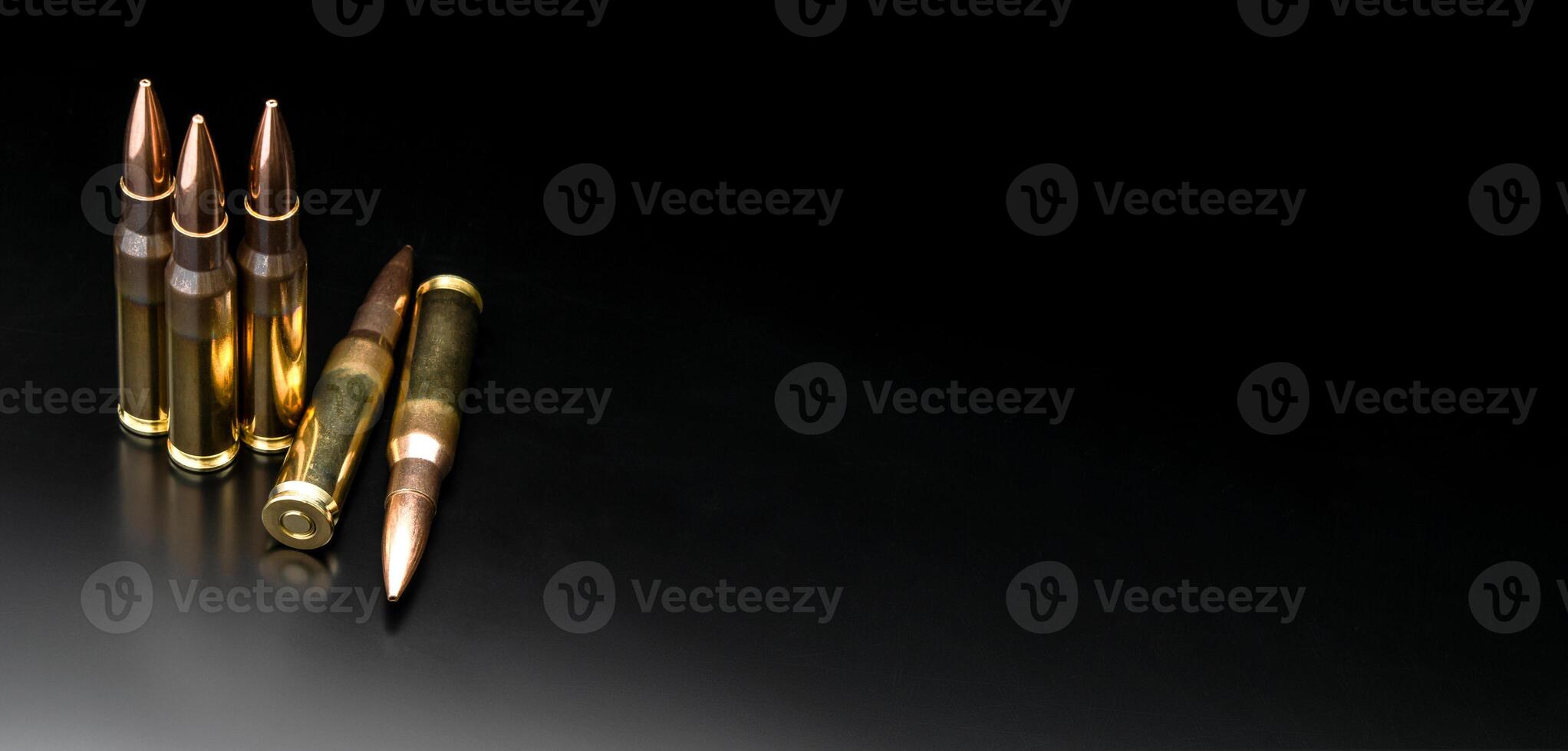Bullet isolated on black background with reflexion. Rifle bullets close-up on black back. Cartridges for rifle and carbine on a black. photo