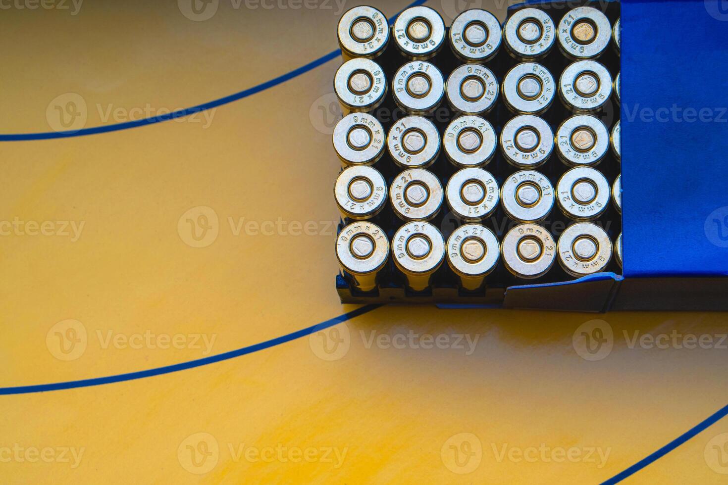 Cartridges in a blue box on a background of a yellow target. 9 mm cartridges for firearms. photo