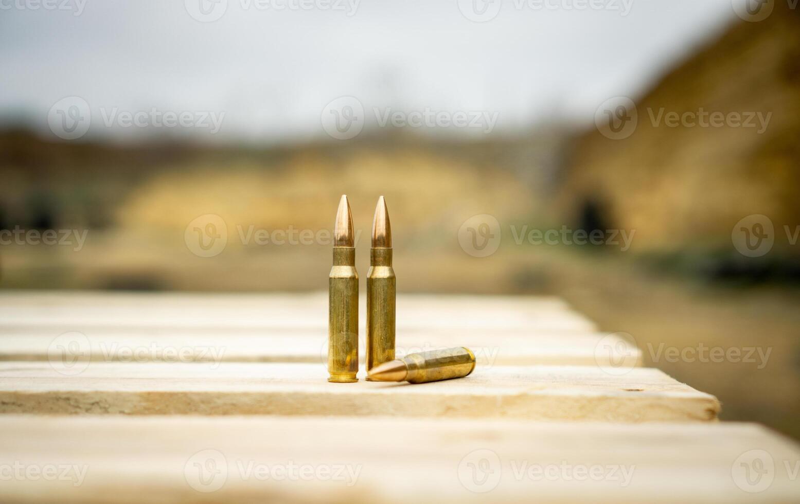 308 caliber ammunition for a rifle standing on a wooden table on the background of the shooting range photo