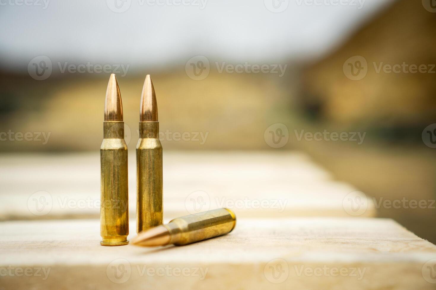 308 caliber ammunition for a rifle standing on a wooden table on the background of the shooting range photo