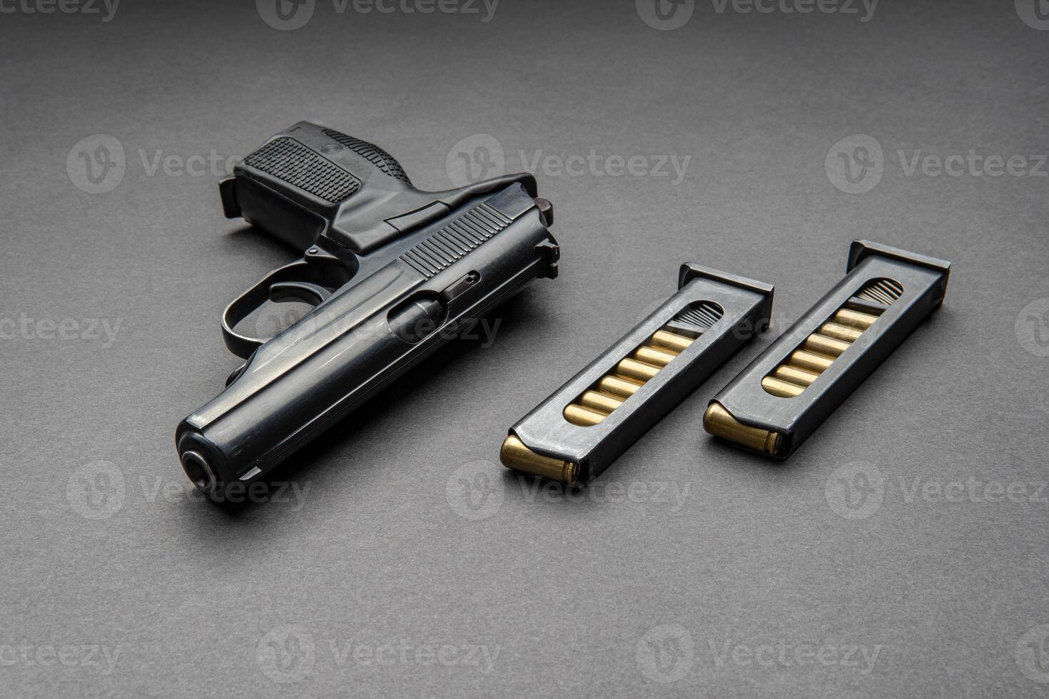 Pistol and cartridges for it on a dark background. A short-barreled weapon for self-defense. photo