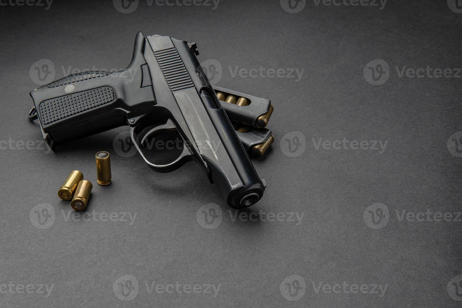 Pistol and cartridges for it on a dark background. A short-barreled weapon for self-defense. photo