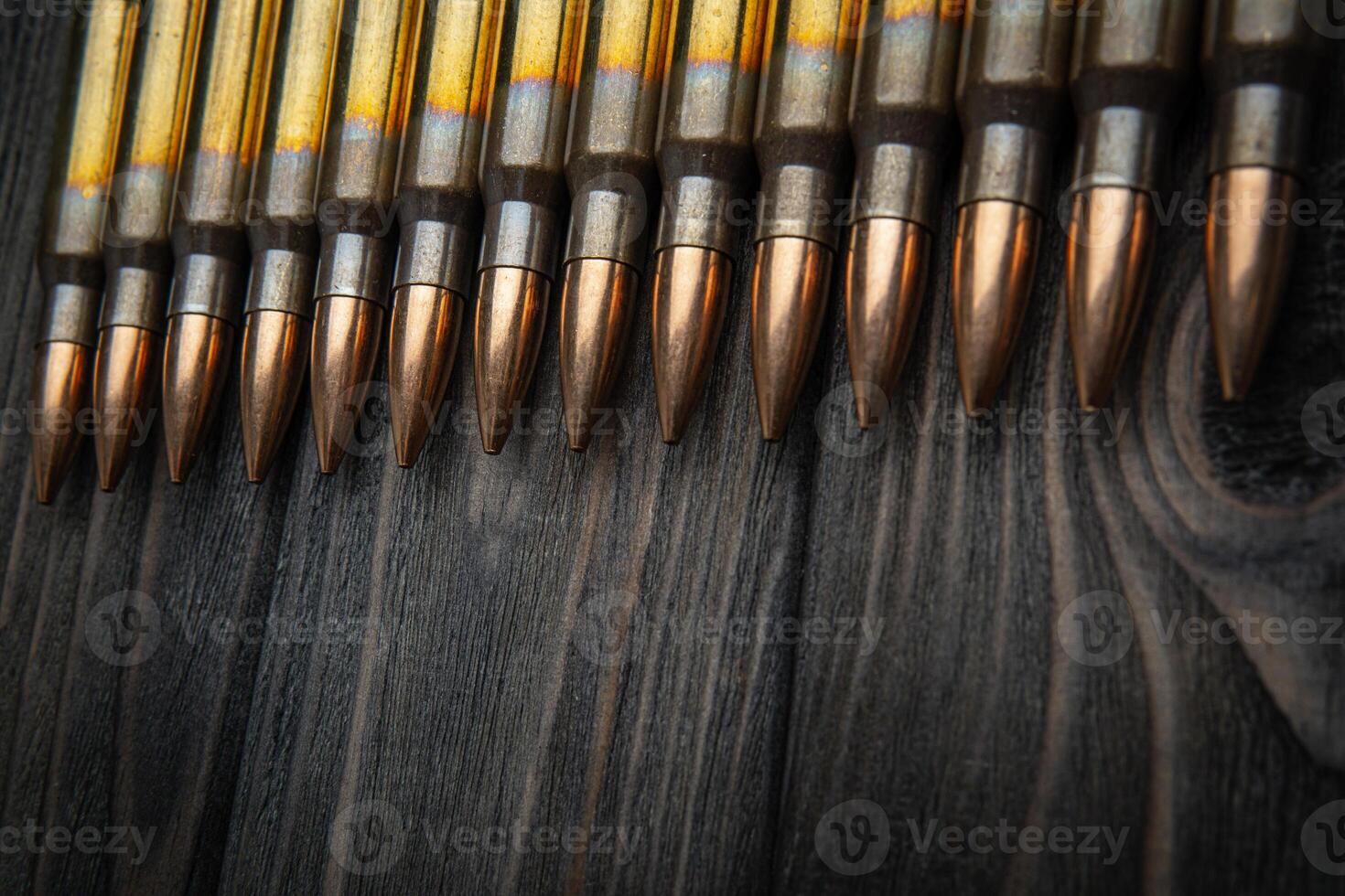 Cartridges for a carbine on a wooden surface. Weapon ammunition on a vintage table. Dark back. photo