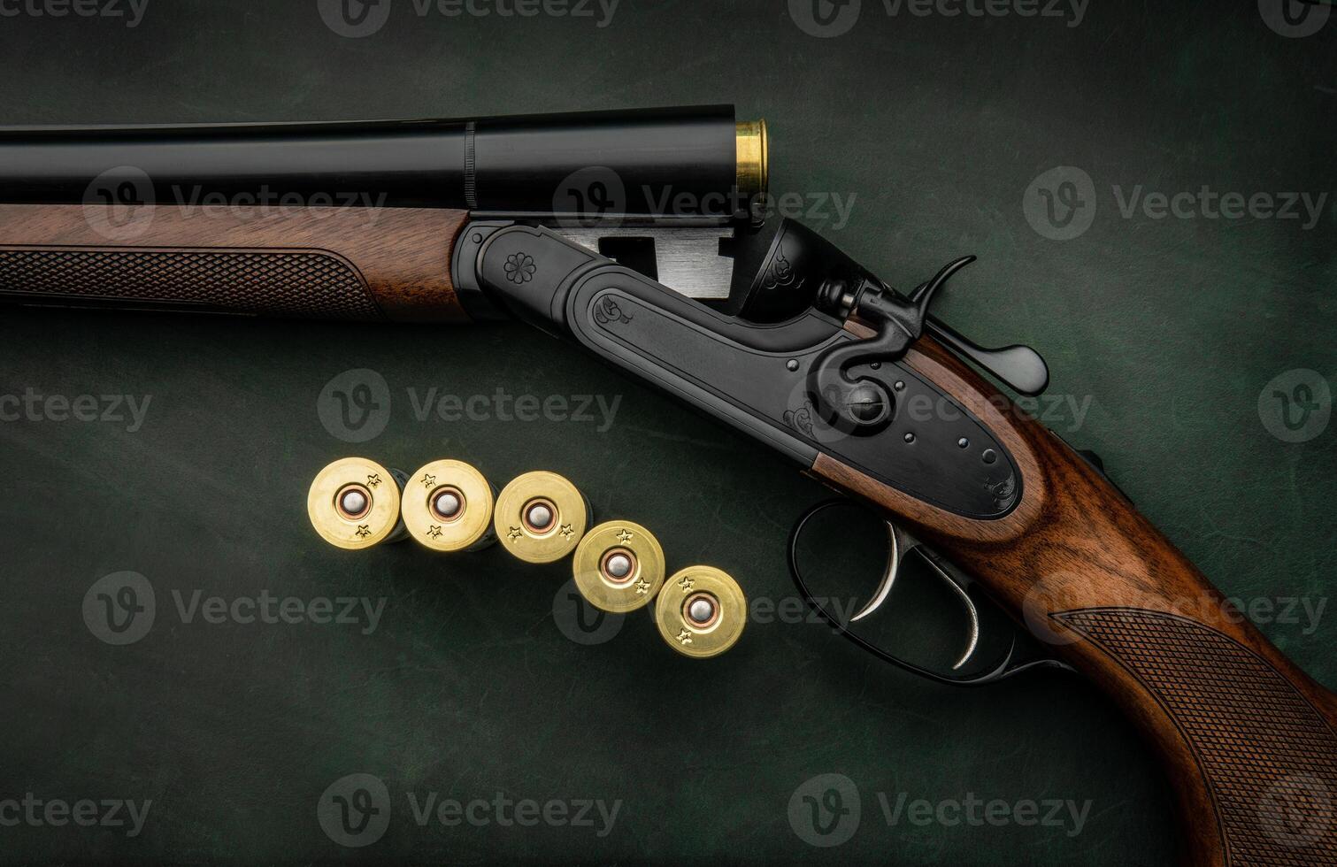 Classic trigger double-barreled hunting rifle on a green background. Smooth-bore hunting rifle open for reloading. Concept postcards for hunters. photo
