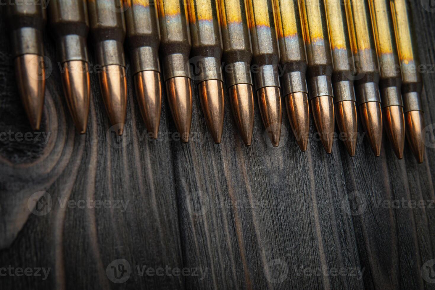 Cartridges for a carbine on a wooden surface. Weapon ammunition on a vintage table. Dark back. photo