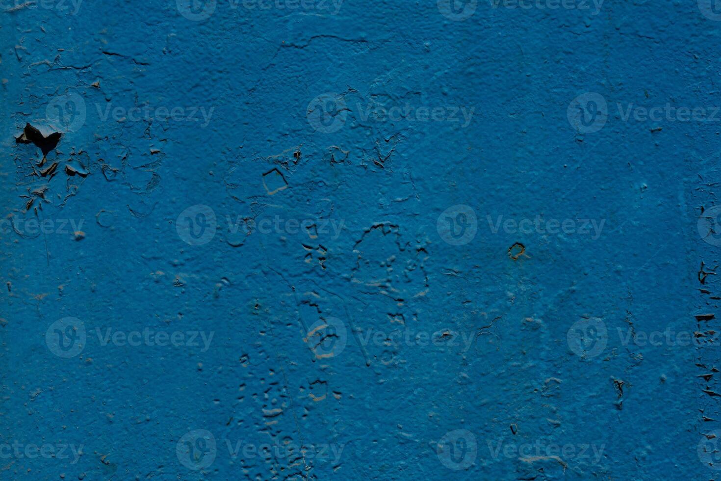 The blue metal surface is cracked by time. Peeling paint rusting metal rough texture. Corrosion and oxidized back. photo