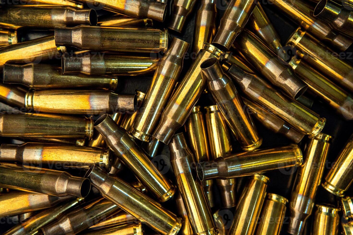 Background from empty cartridges for rifles and carbines. Shiny brass shells scattered on the surface. photo