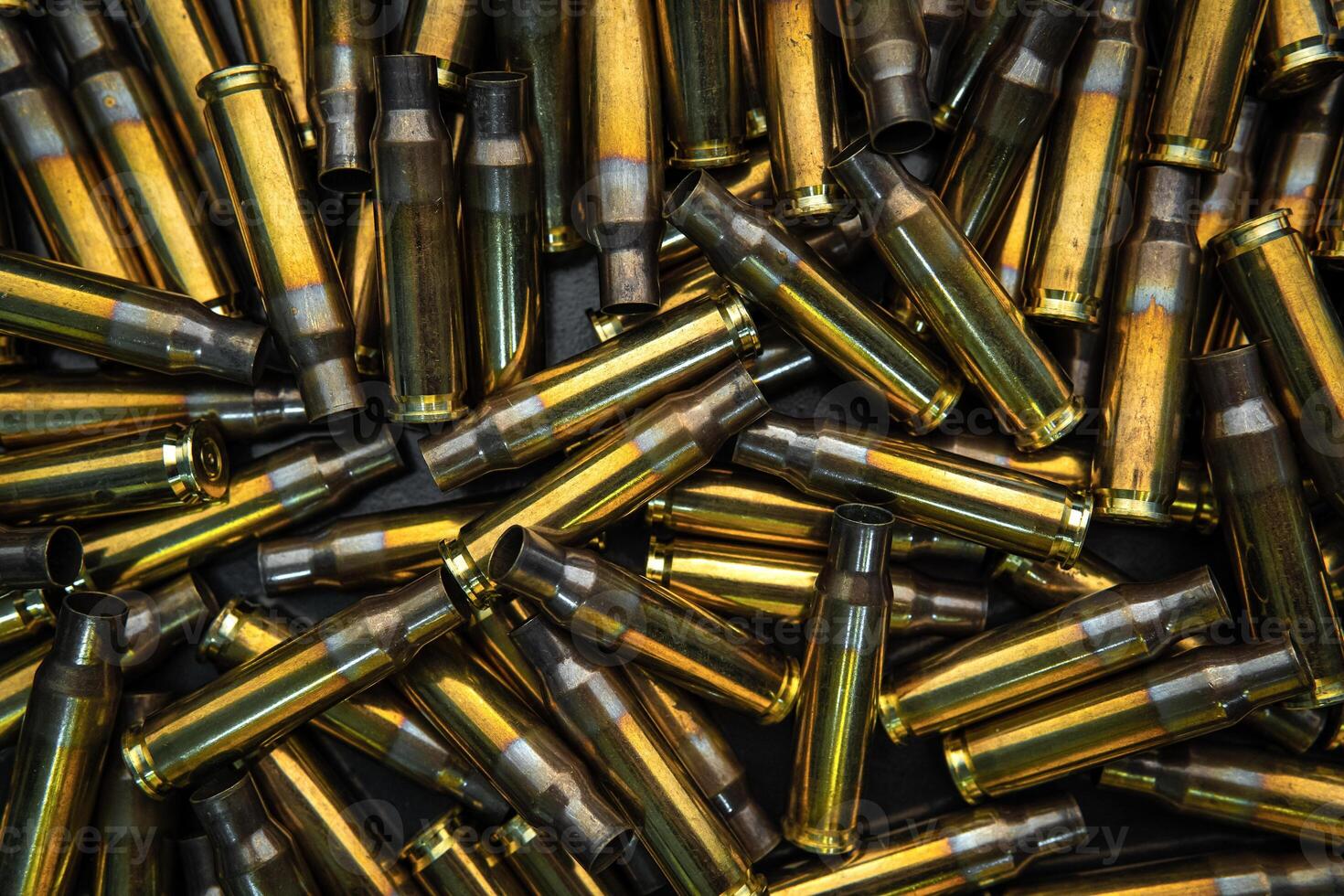Background from empty cartridges for rifles and carbines. Shiny brass shells scattered on the surface. photo