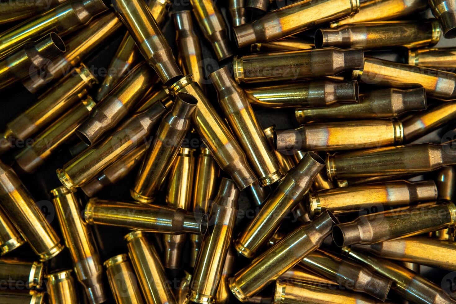 Background from empty cartridges for rifles and carbines. Shiny brass shells scattered on the surface. photo