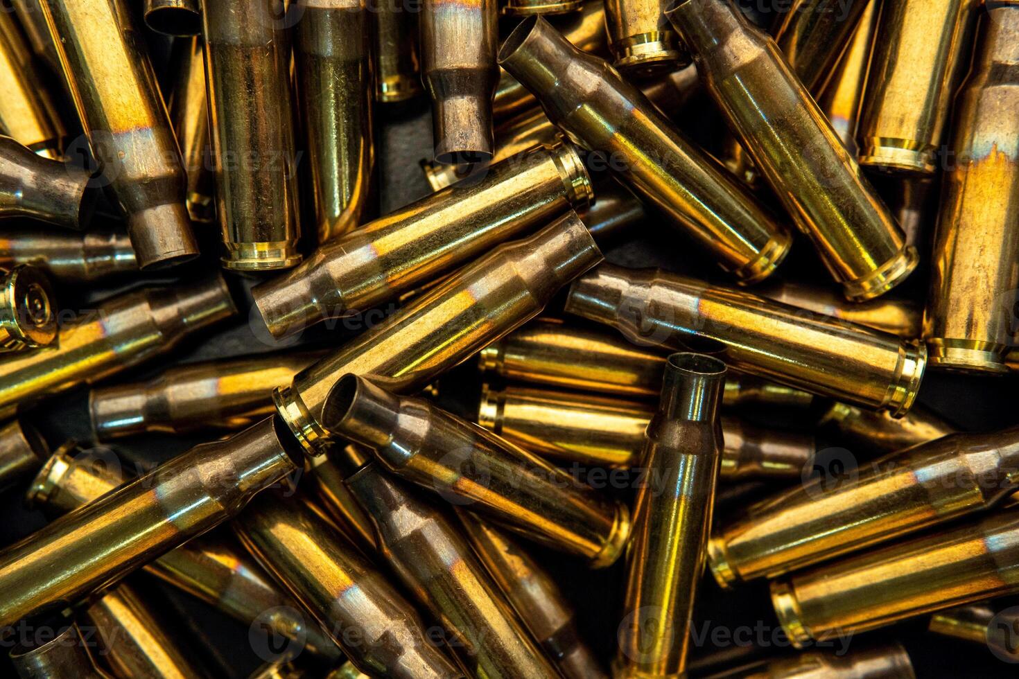 Background from empty cartridges for rifles and carbines. Shiny brass shells scattered on the surface. photo