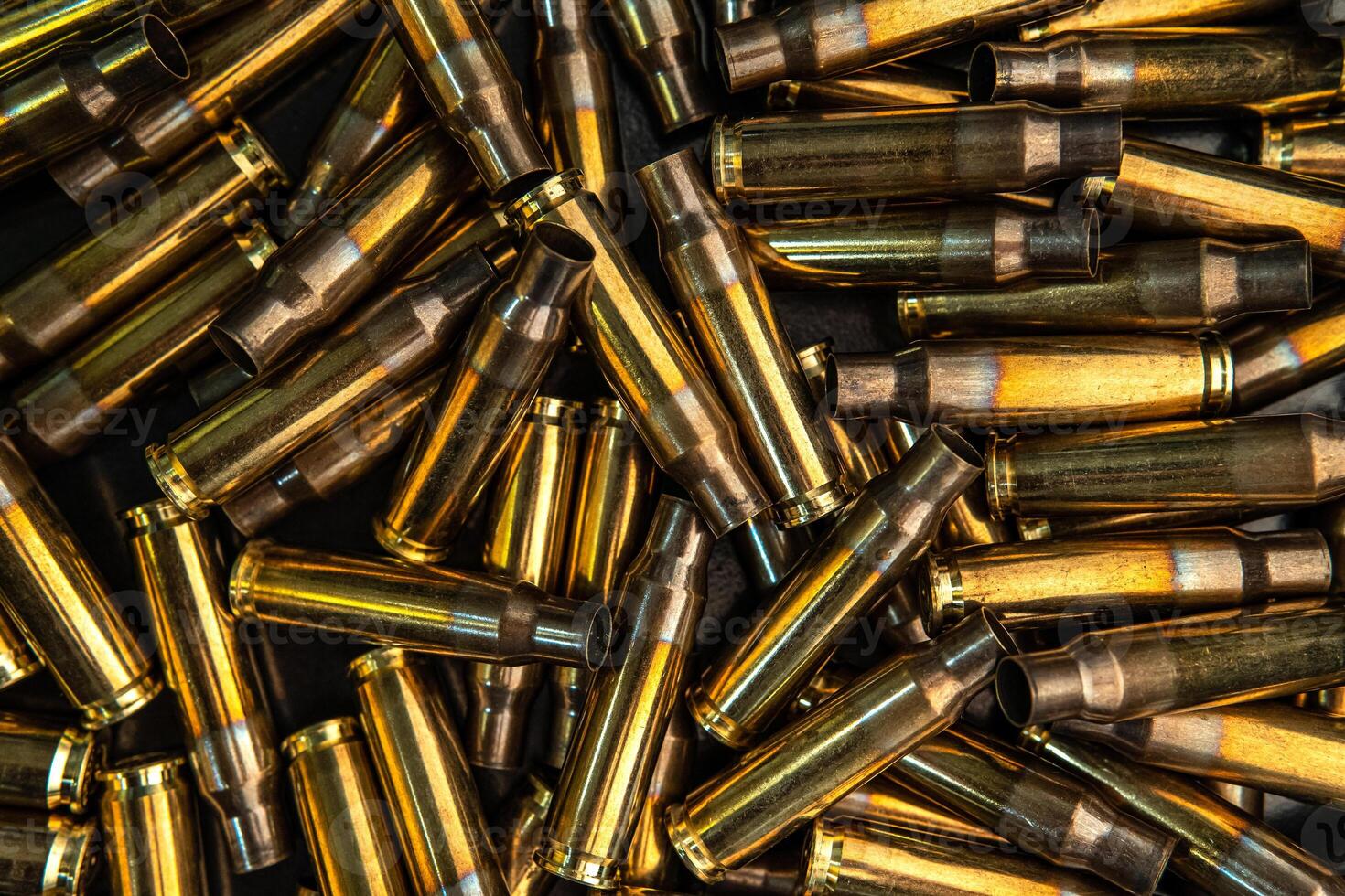 Background from empty cartridges for rifles and carbines. Shiny brass shells scattered on the surface. photo
