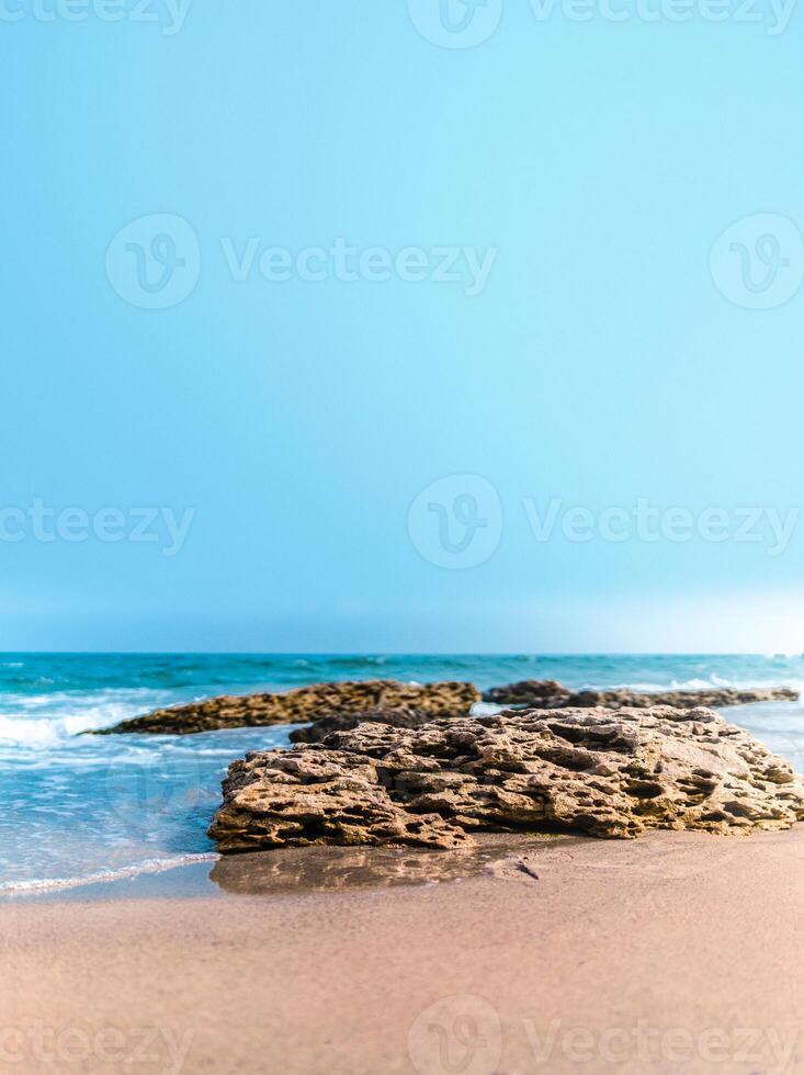 Soft wave crashing stone at bay. Stones by the sea. Sea wave breaks on beach rocks landscape. Sea waves crash and splash on rocks. Beach rock sea wave breaking. photo