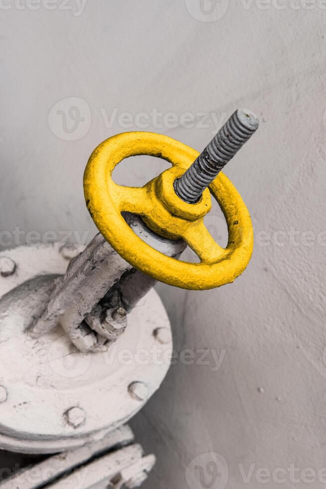 Old industrial valve on light background. A metal pipeline valve, old weathered gas crane and pipe .Old valves have rust, Circular handle, Old valves assembled with steel pipes. photo