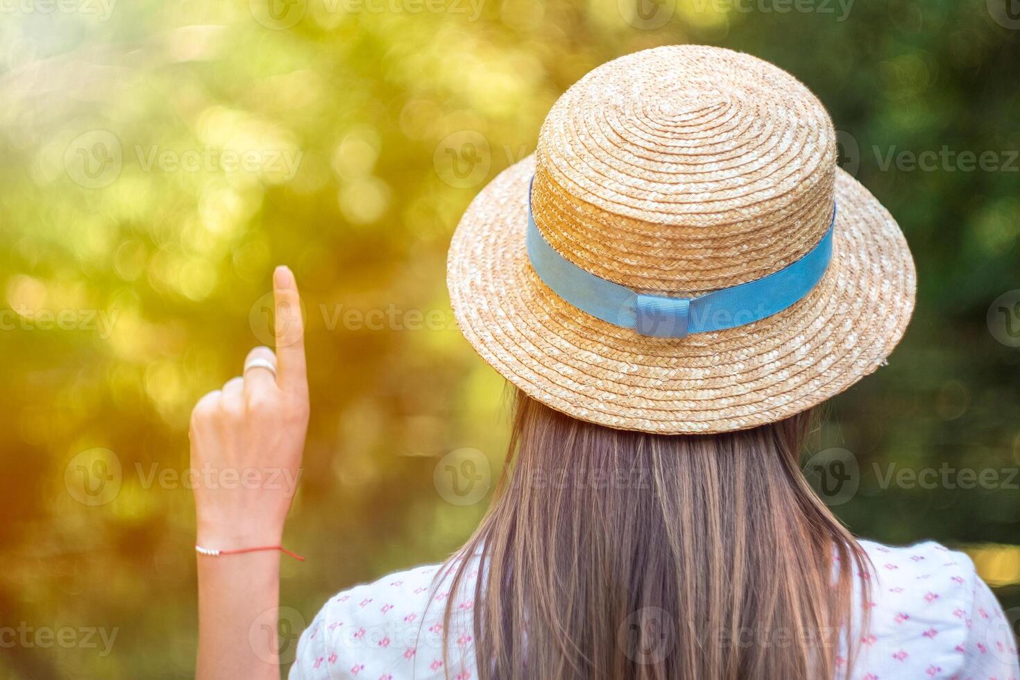 girl in a straw hat on a green photo