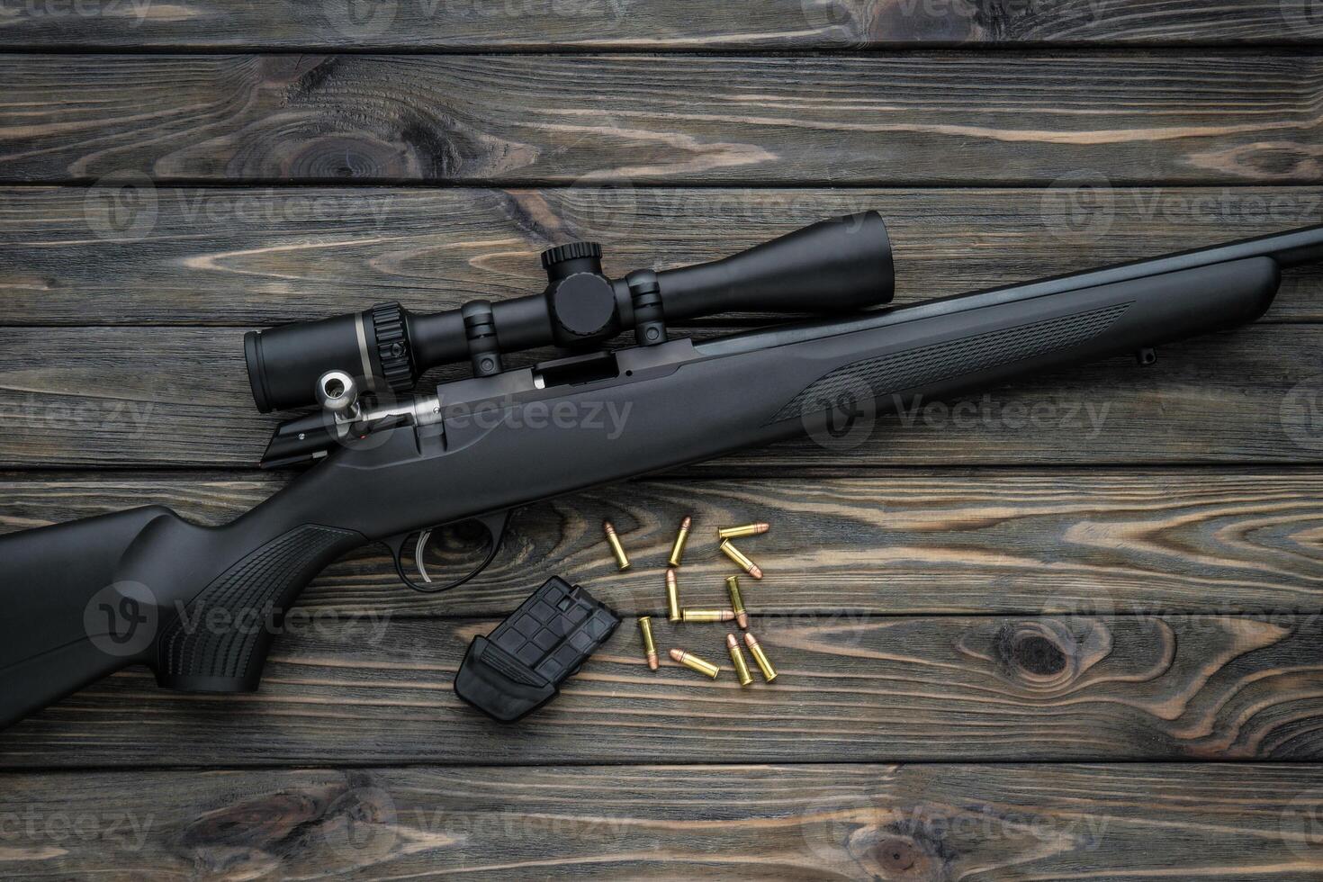 Bolt small caliber rifle 22lr with an optical sight on a wooden back. Hunting small-caliber weapon on a wooden table. photo