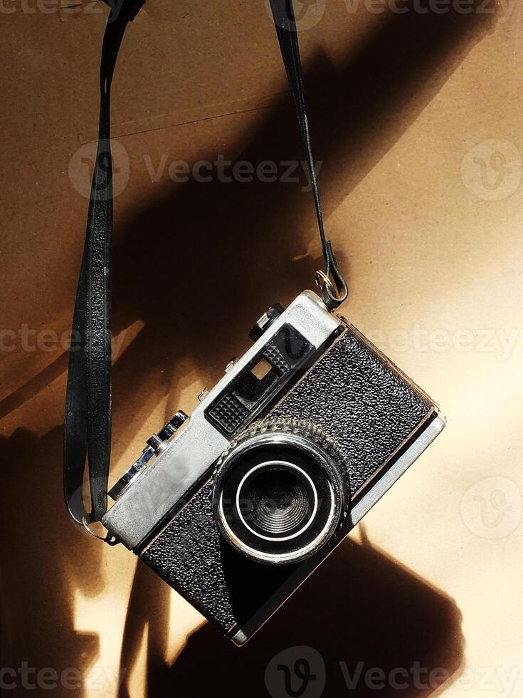 old vintage camera gear hanging with drop shadow background. Available light. Retro vintage concept. Travel and journey design element photo