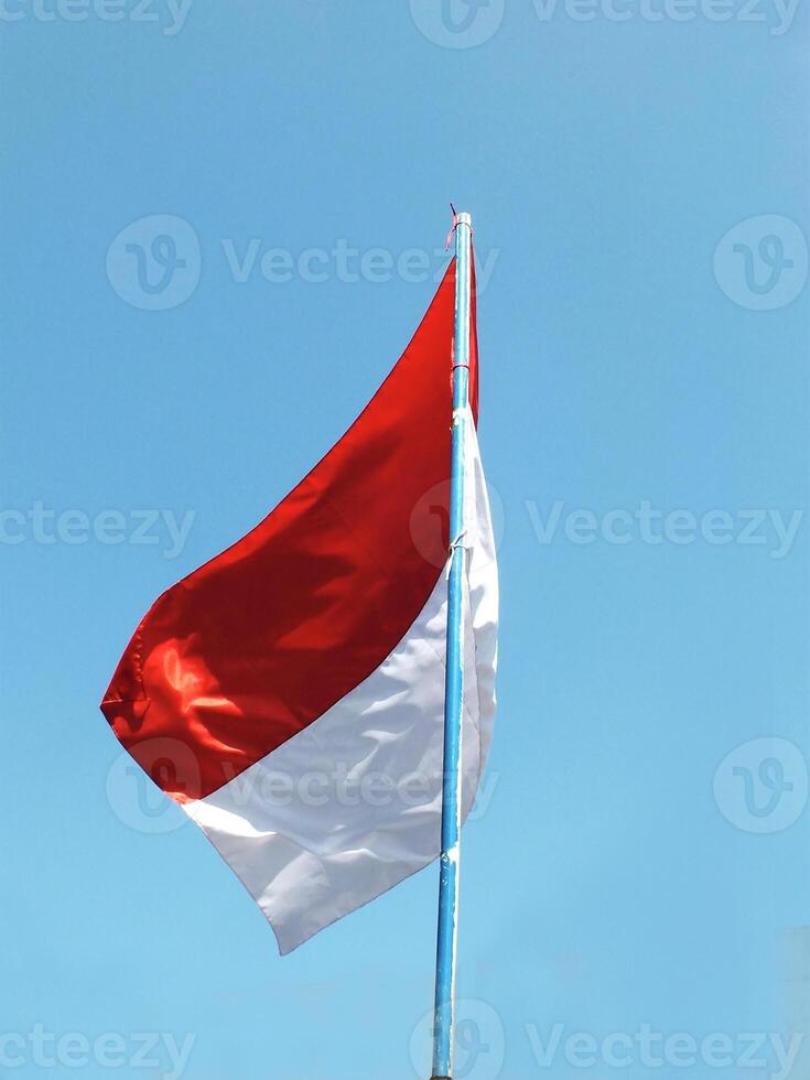 Indonesia national flag waving in the wind with clear blue sky background. Nation patriotsm. The Hari Kemerdekaan Indonesia photo