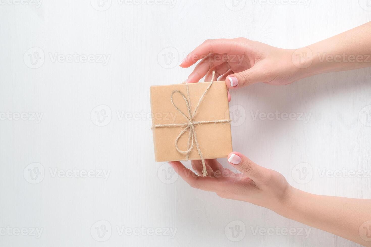 hands of a young girl holding a gift box on a white background photo