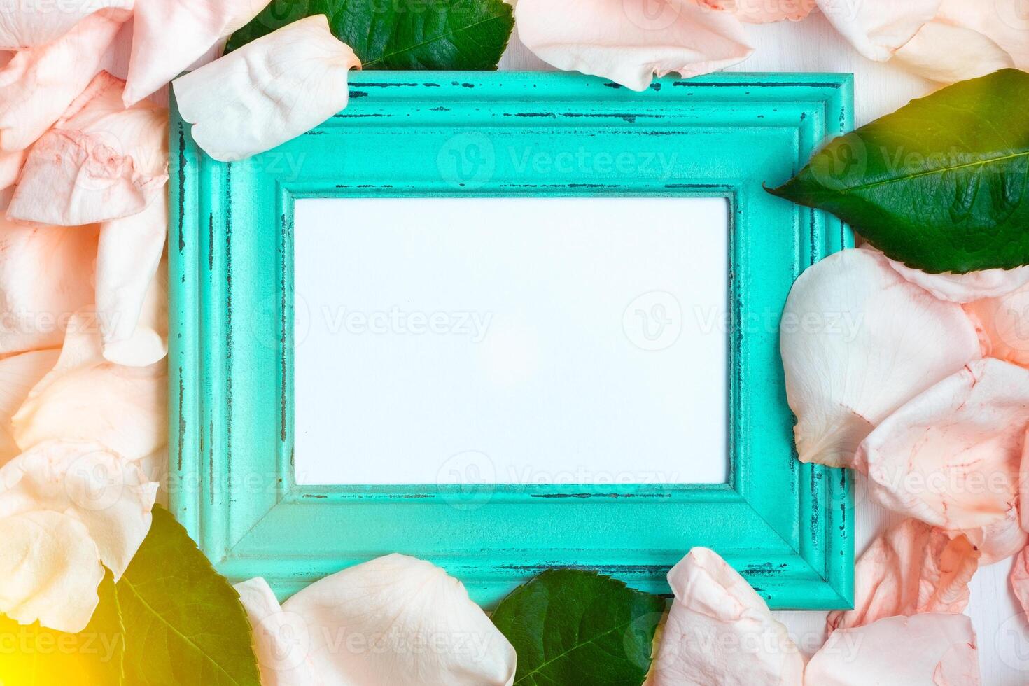 Wooden frame among the petals of roses. photo
