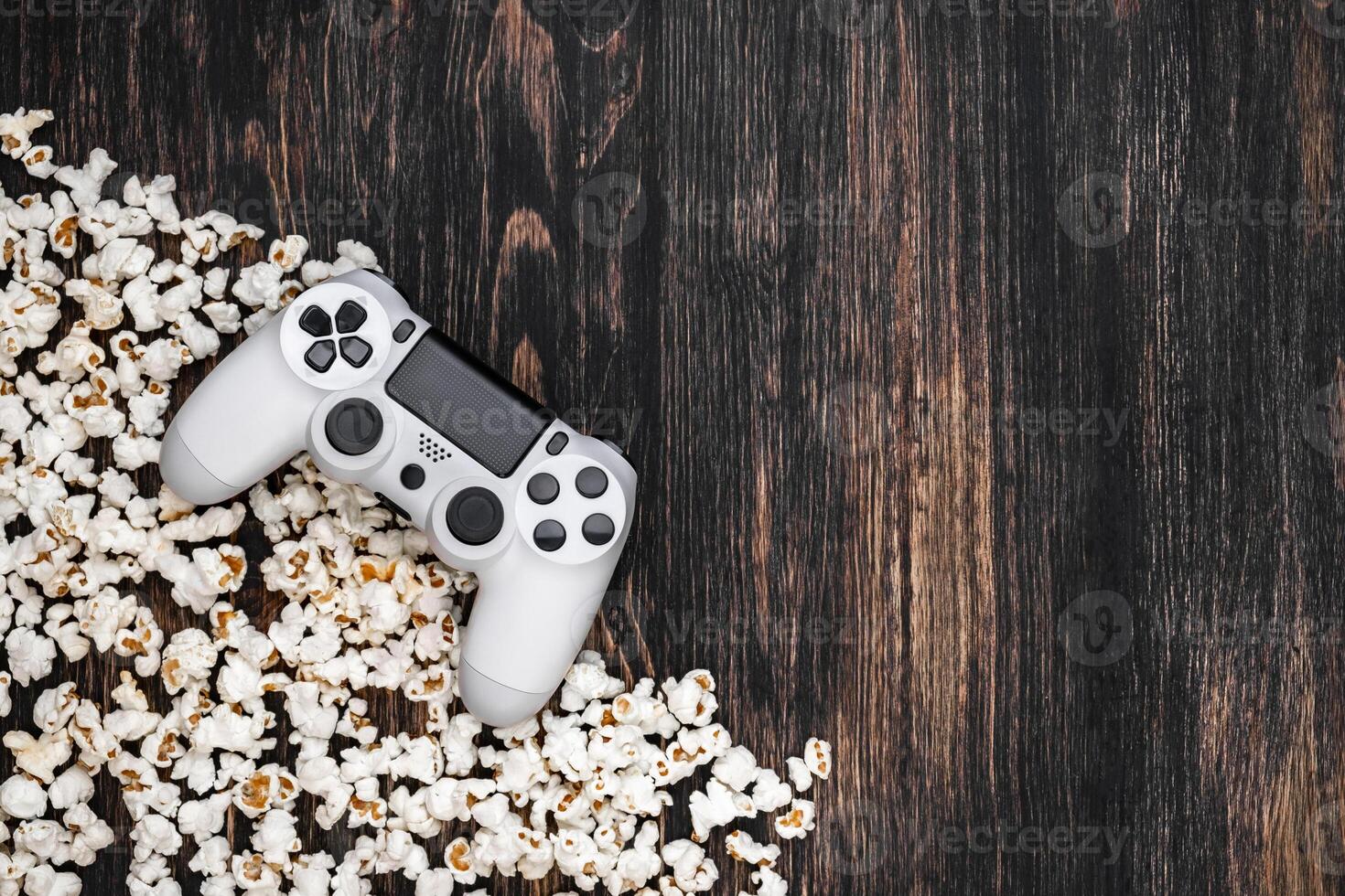 gamepad and popcorn on a wooden background photo