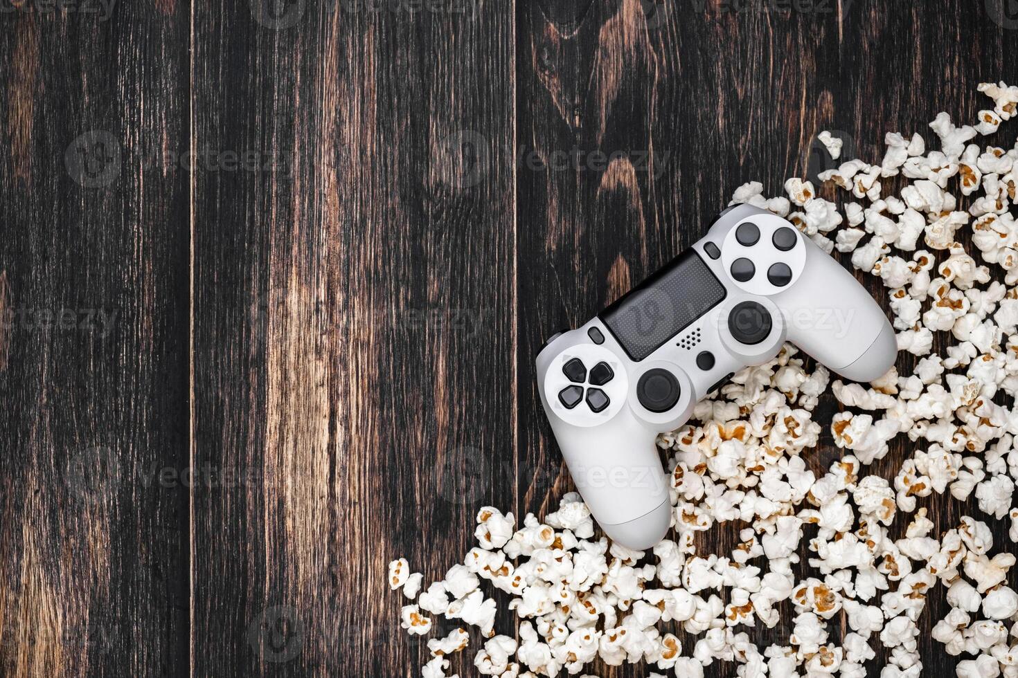 gamepad and popcorn on a wooden background photo