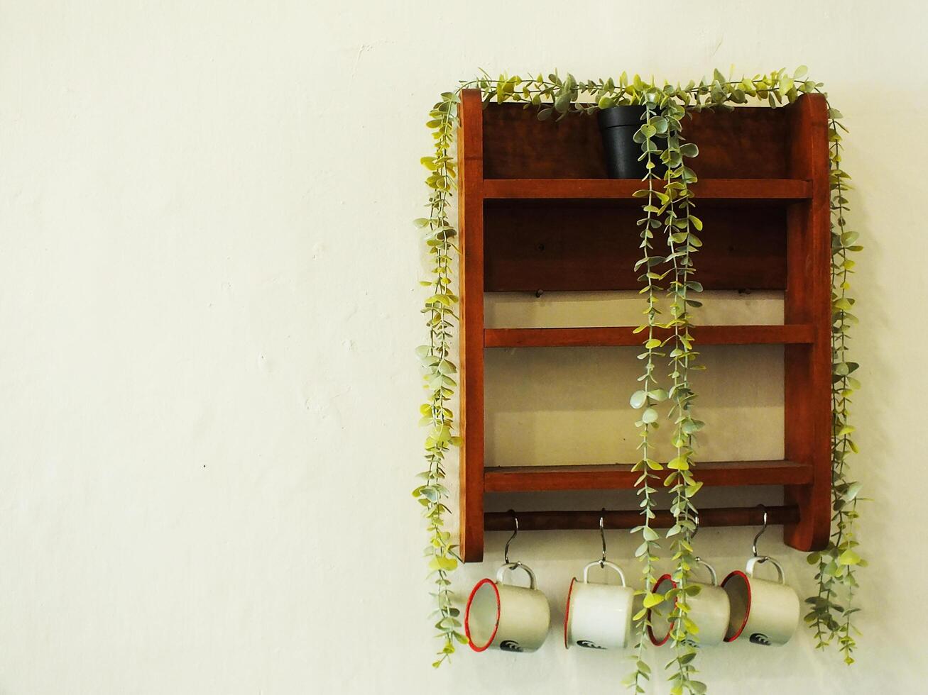 Retro vintage interior design. Wooden shelves with artificial plants, vintage enamel cup. Copy space for text message photo