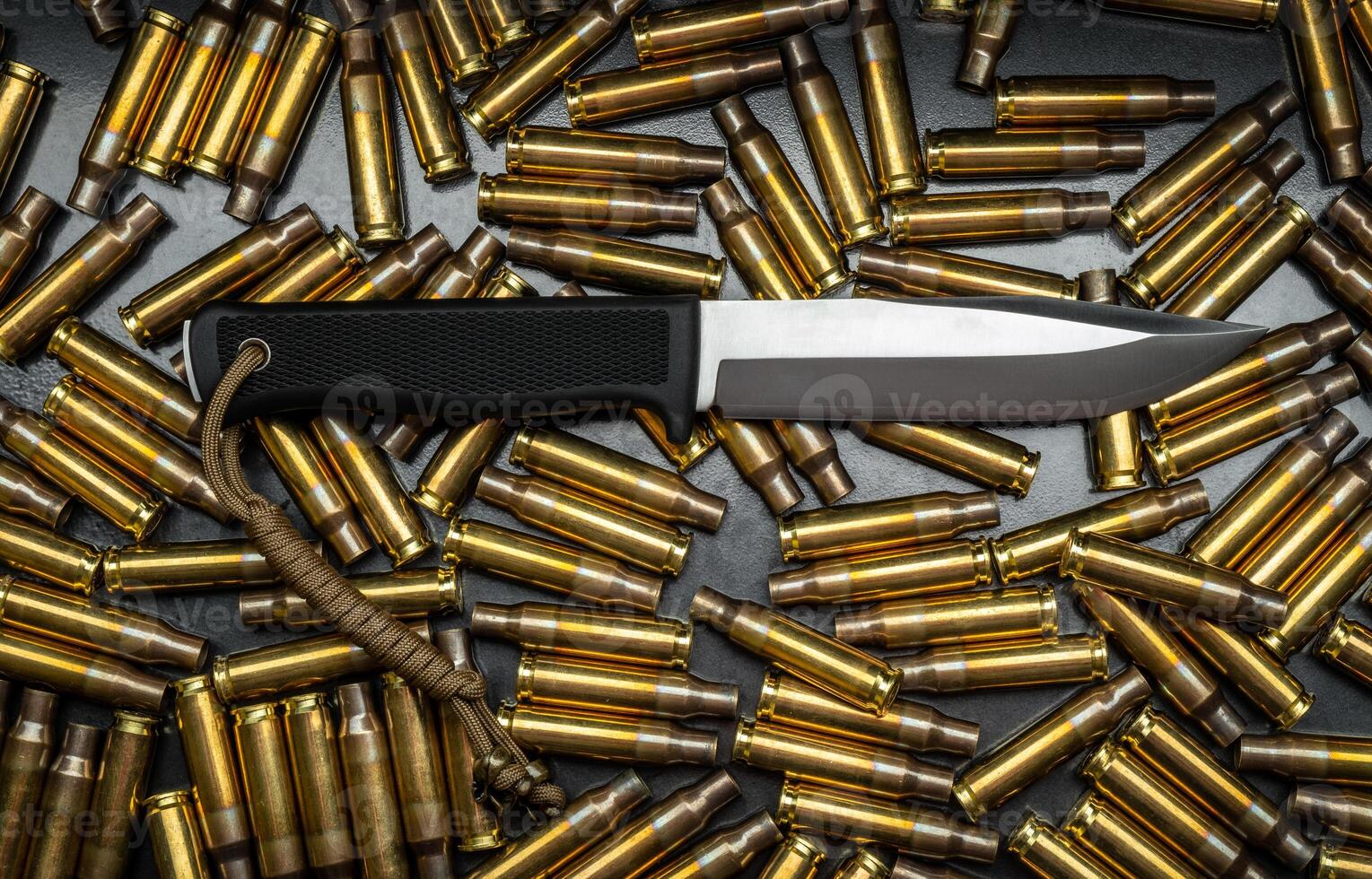 A modern military or hunting knife against a background of gun cases. photo