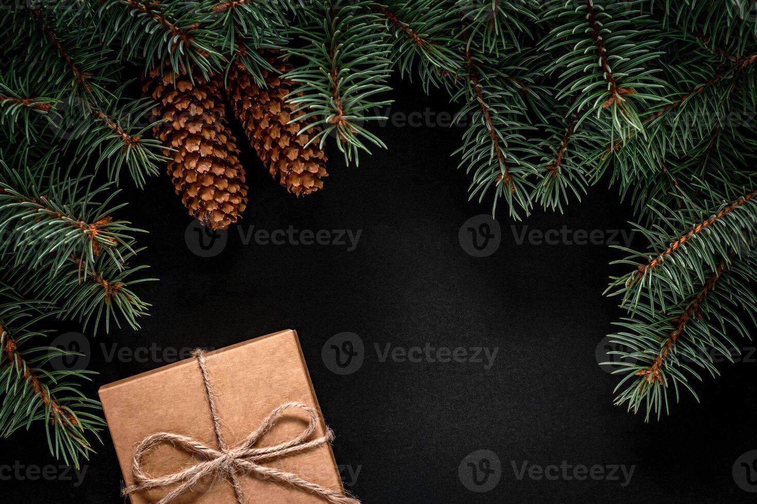 A frame of fir branches and gift paper box tied with twine. Christmas card blank. photo