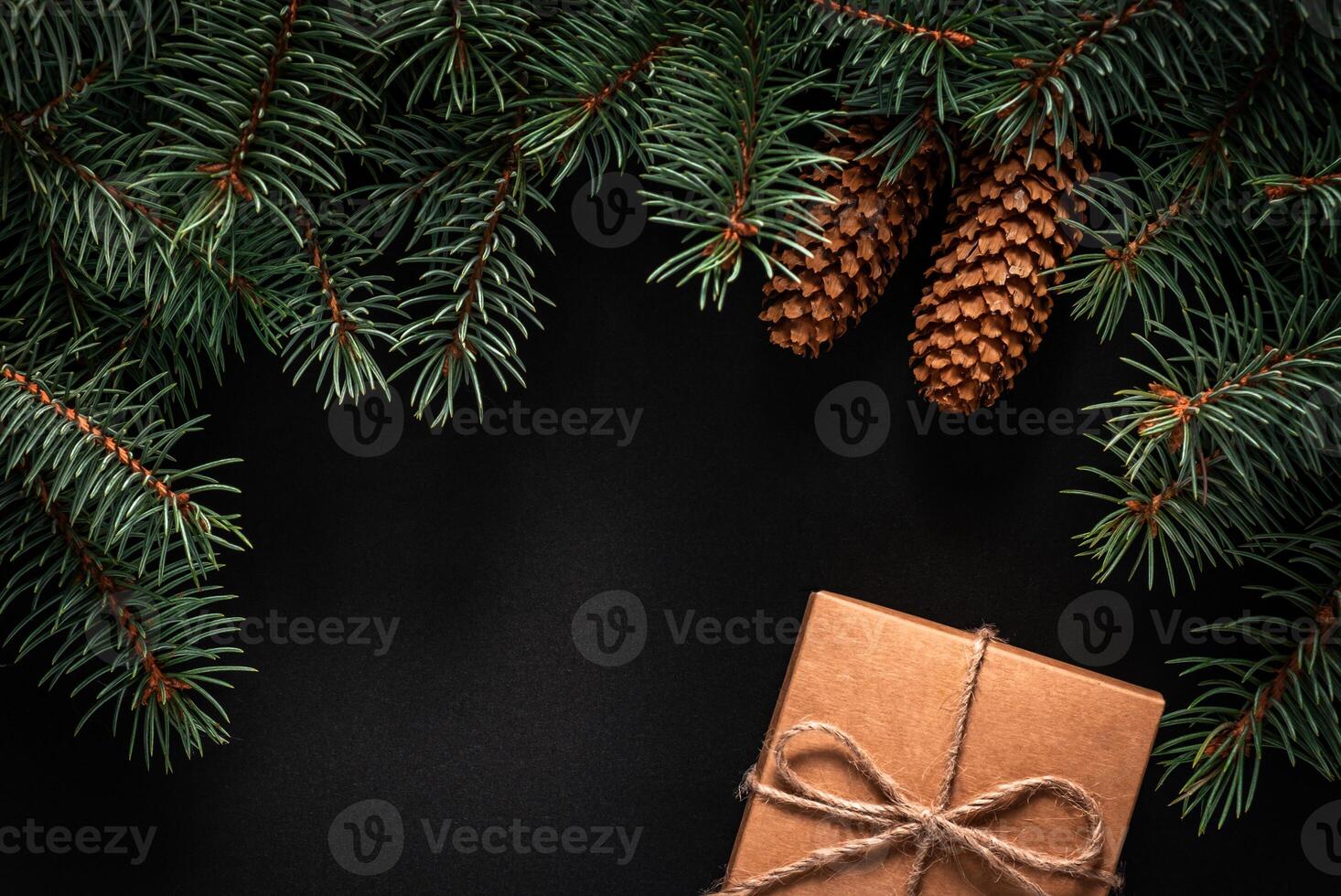 A frame of fir branches and gift paper box tied with twine. Christmas card blank. photo