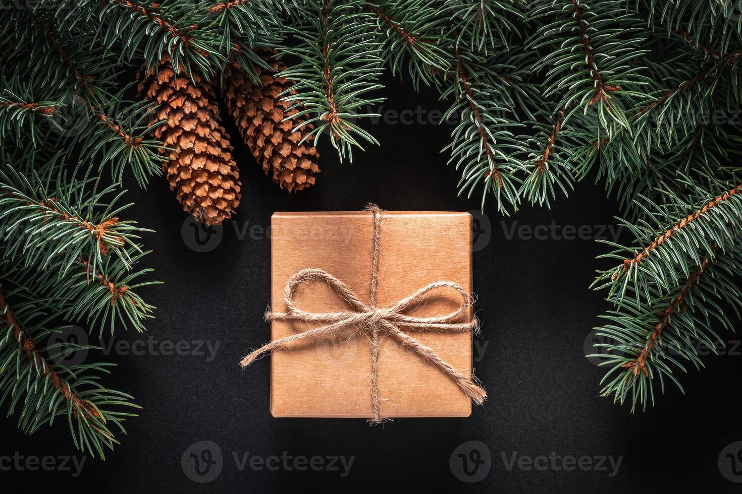 A frame of fir branches and gift paper box tied with twine. Christmas card blank. photo