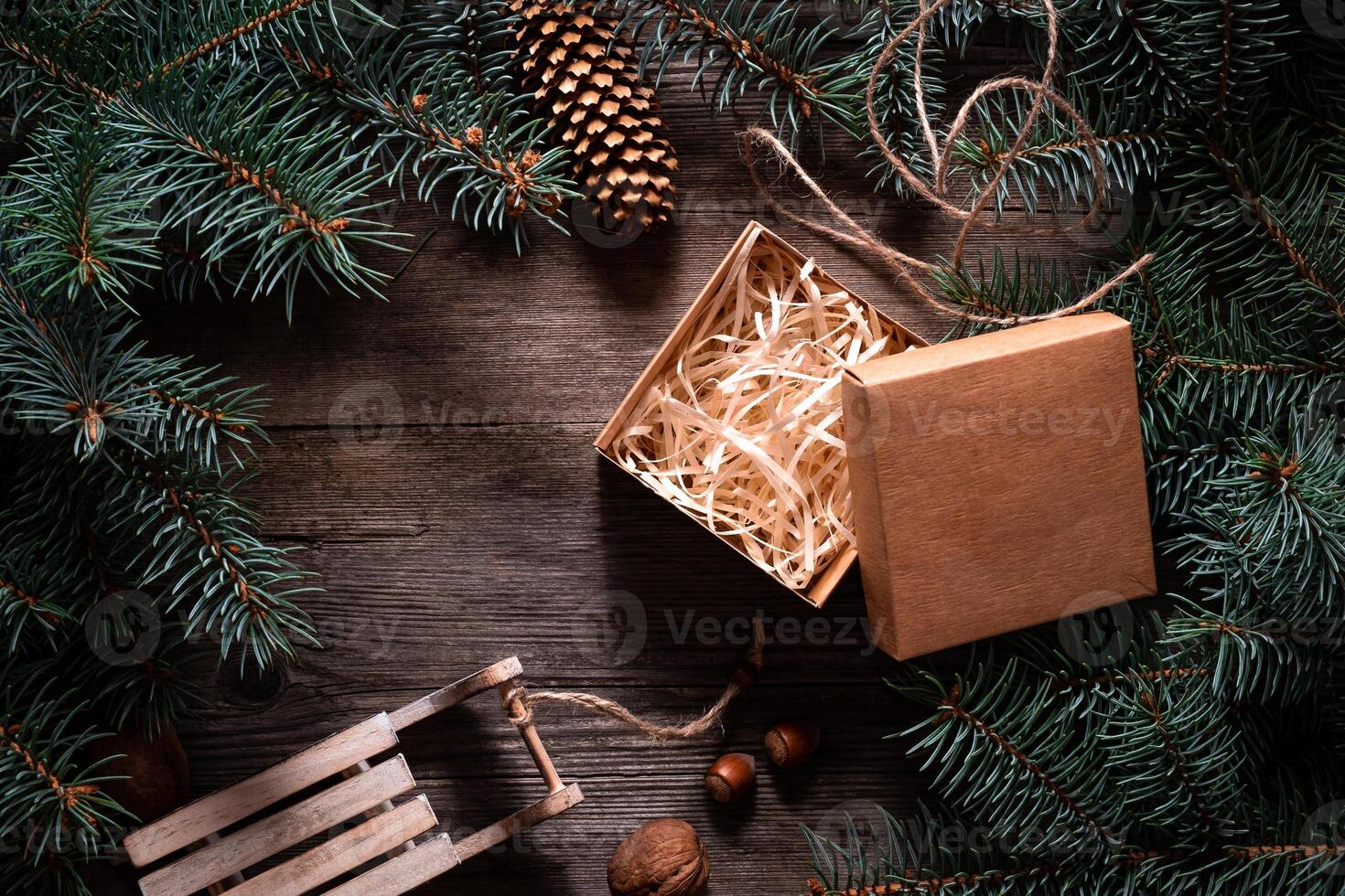 A frame of fir branches and an open gift paper box tied with twine. Christmas card blank. photo