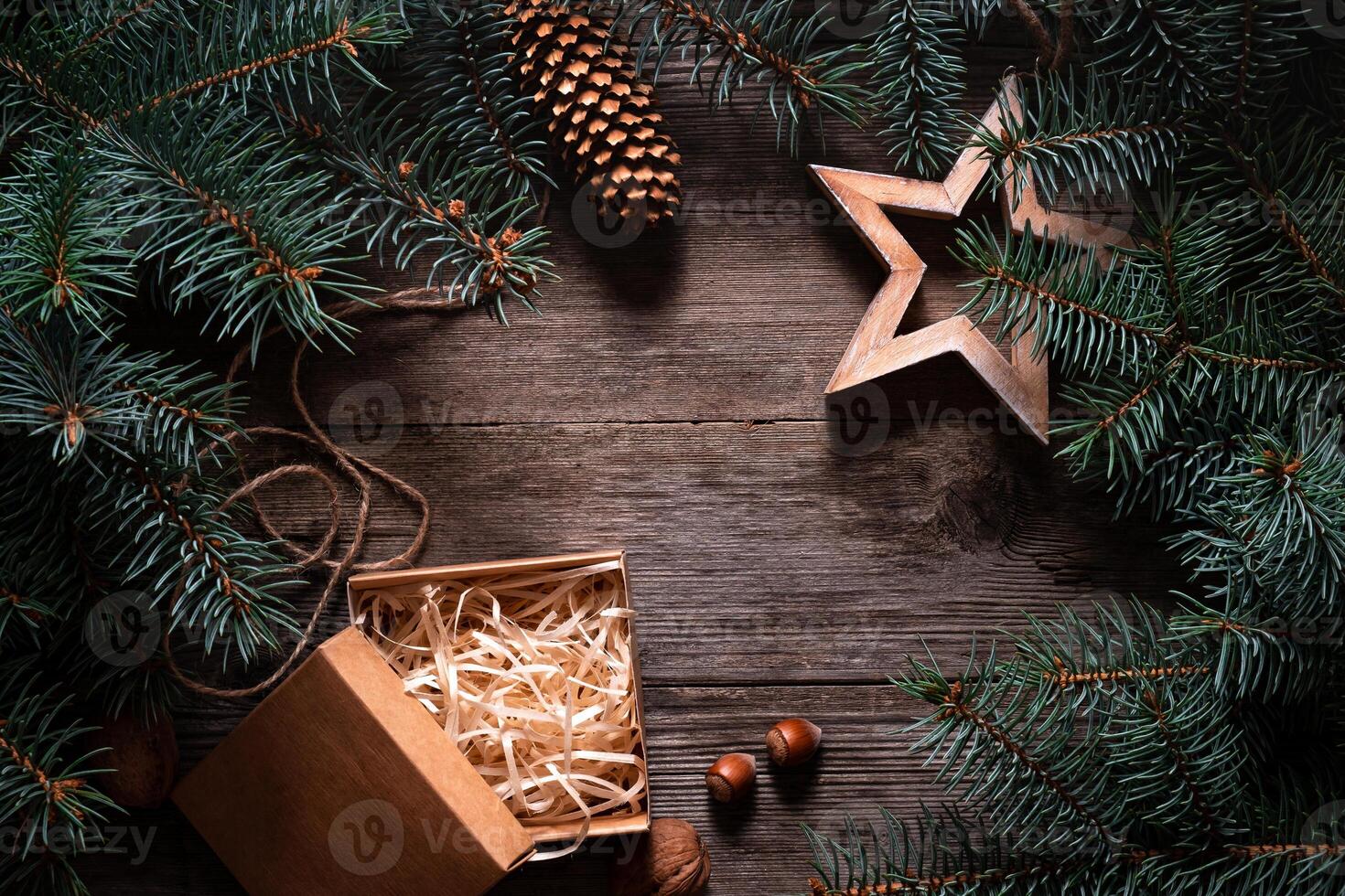 A frame of fir branches and an open gift paper box tied with twine. Christmas card blank. photo