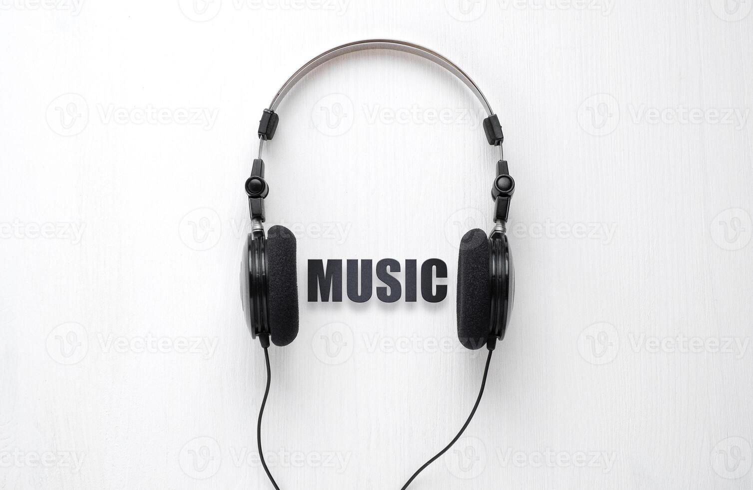 Wired headphones for listening to music on a white wooden back. Concept to illustrate listening to music. photo