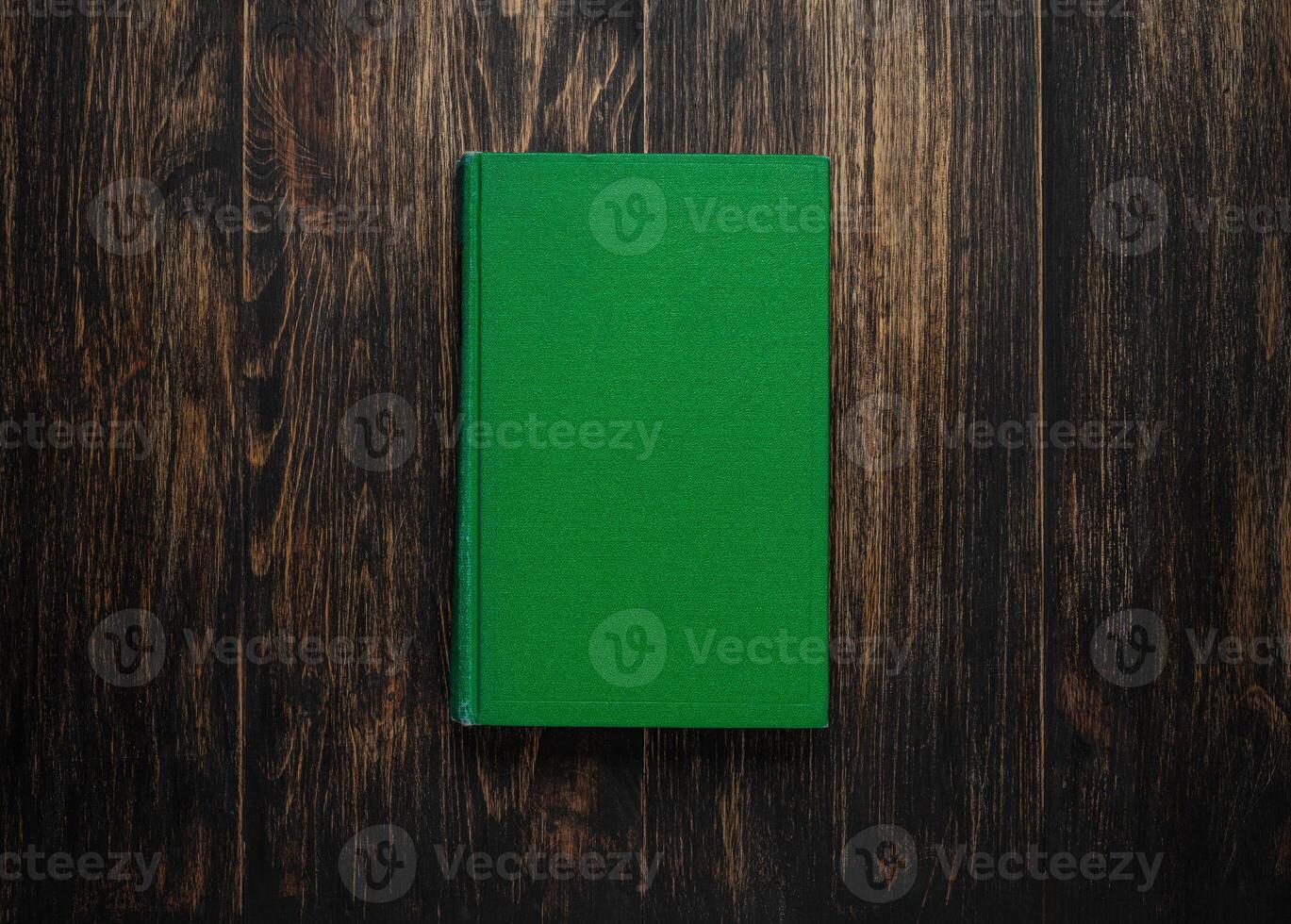 Closed book on vintage wooden background. Old book on the wooden table. Closed book with empty cover laying on wooden table. photo