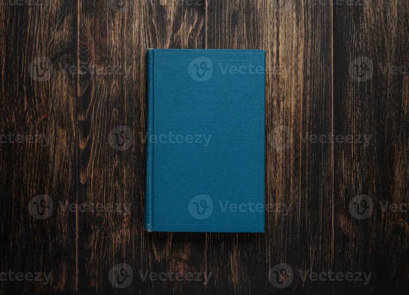 Closed book on vintage wooden background. Old book on the wooden table. Closed book with empty cover laying on wooden table. photo