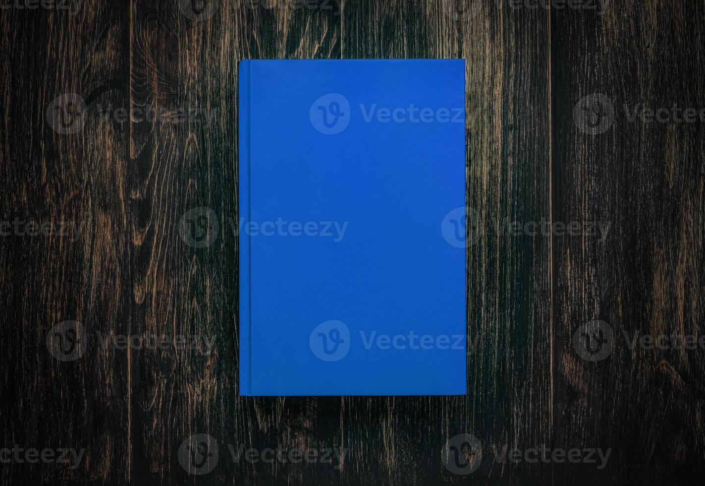 Closed book on vintage wooden background. Book on the wooden table. Closed book with empty cover laying on wooden table. photo