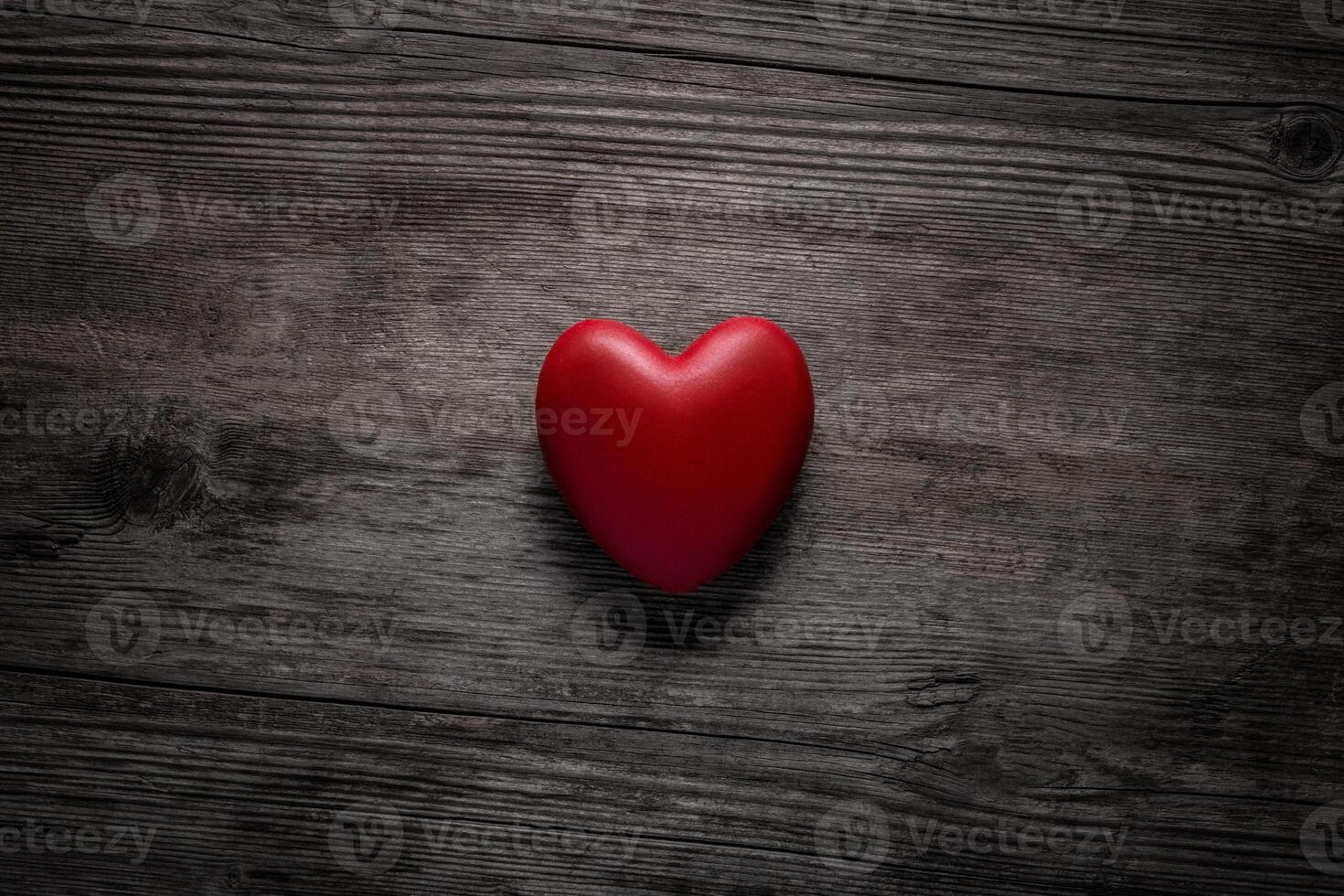 Red heart on vintage wooden background. Valentine day concept. Top view red heart on old wood texture background with copy space for text. photo