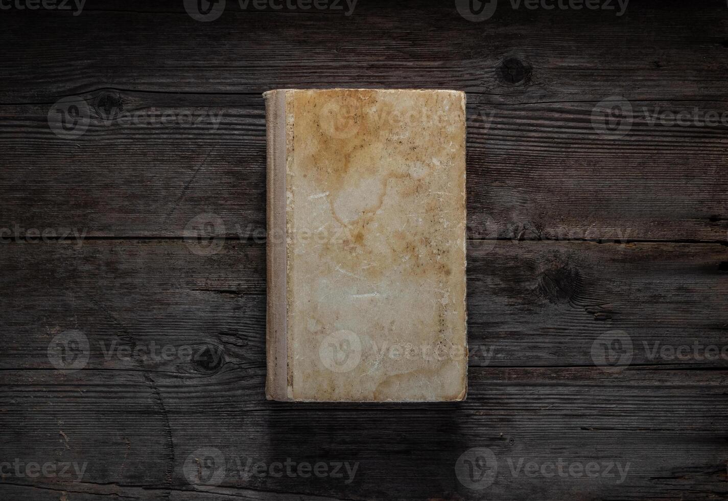 Closed book on vintage wooden background. Old book on the wooden table. Closed book with empty cover laying on wooden table. photo
