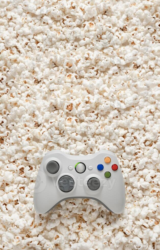 White gamepad on popcorn back. Game poster or postcard concept. Rest for the game and popcorn. photo